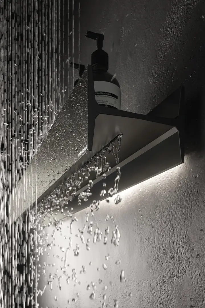 Black and white detail of water breaking over a wall-mounted spout