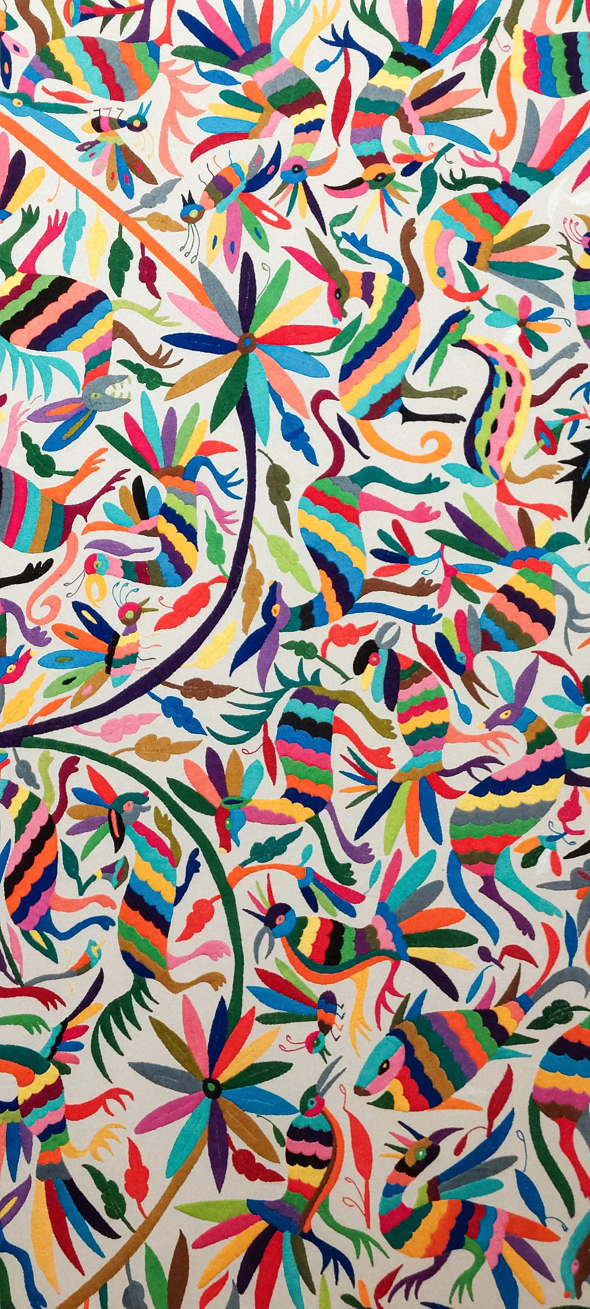 Otomí embroidery in dense colour on undyed cloth — birds, deer and flowering vines hand-stitched edge to edge