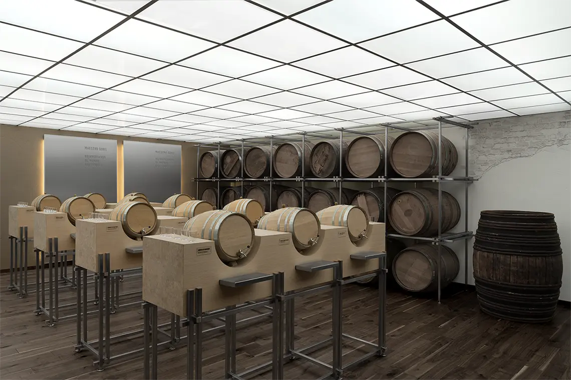 Barrel room — oak casks stacked on steel racking, each of a row of standing tables carrying a small barrel with its own tap