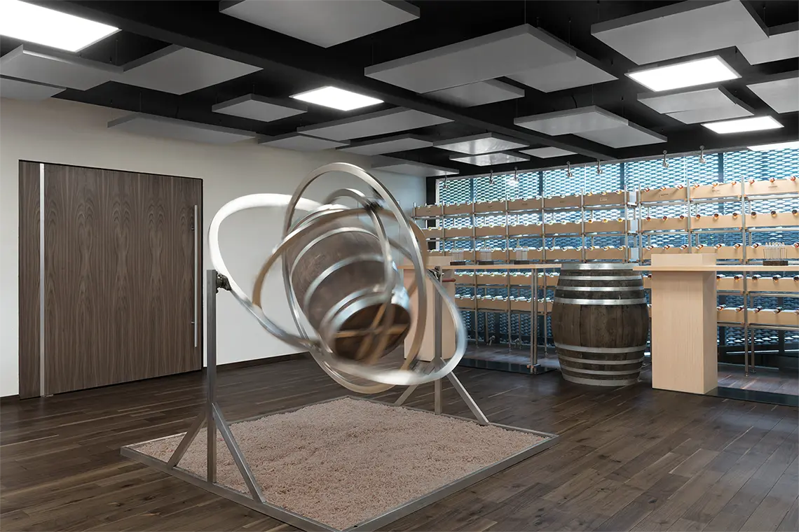A cask held inside a cradle of polished steel rings, standing on a bed of sand under a coffered black ceiling