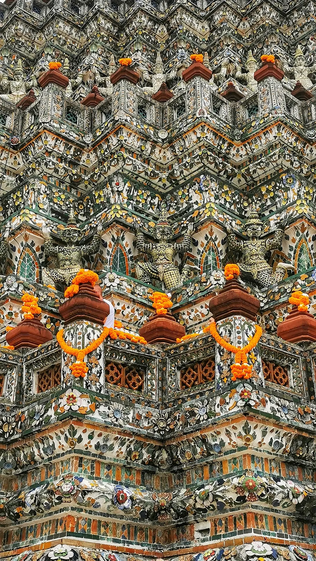 Densely carved and painted architectural surface, tier upon tier of polychrome figures filling the frame
