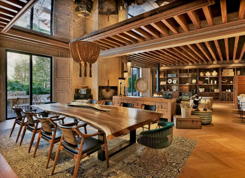 Hotel restaurant under an exposed timber ceiling, banquette seating along a glazed wall