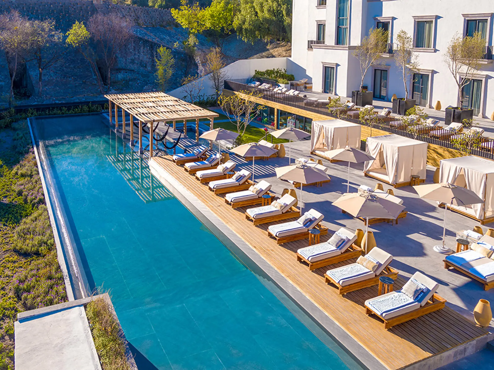 Aerial view of the hotel's pool terrace, loungers lined along a long rectangular pool