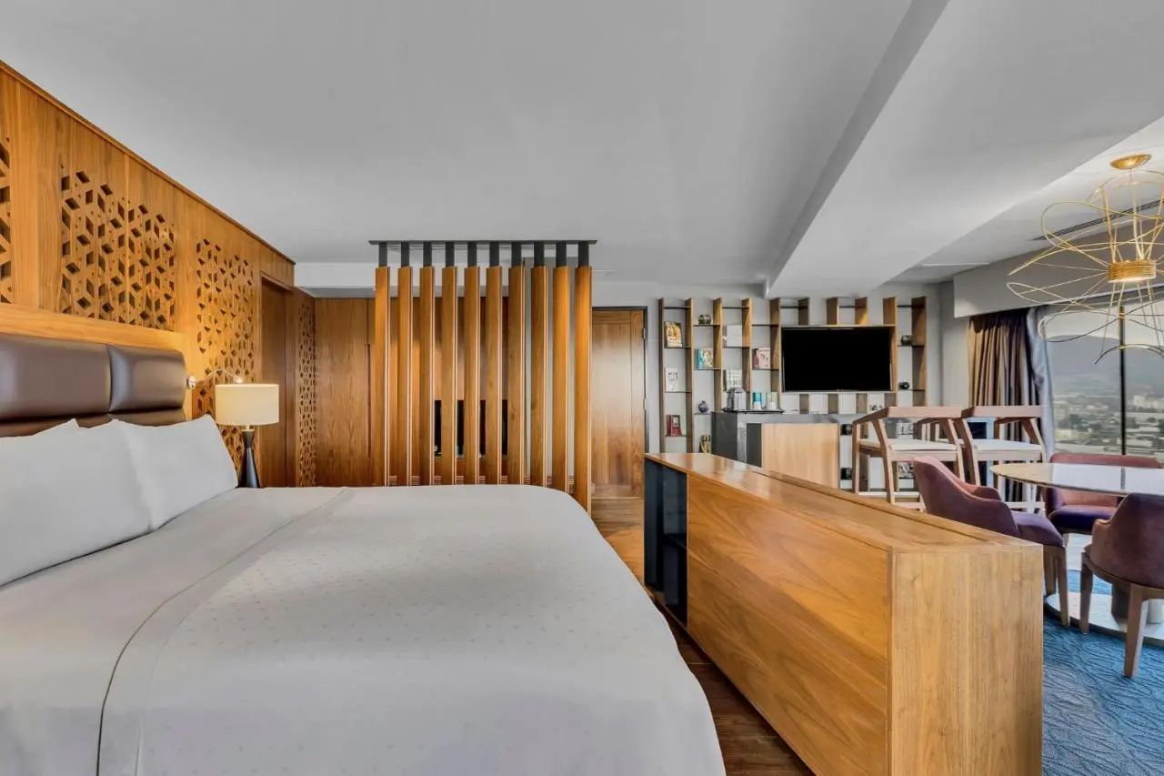 Guest room bed against a timber-battened wall