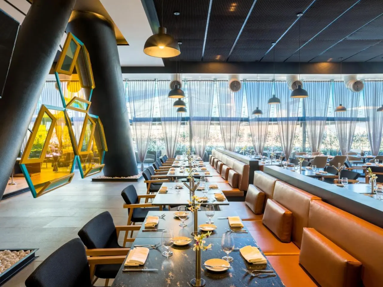 Hotel restaurant, yellow structural columns rising through a double-height dining room