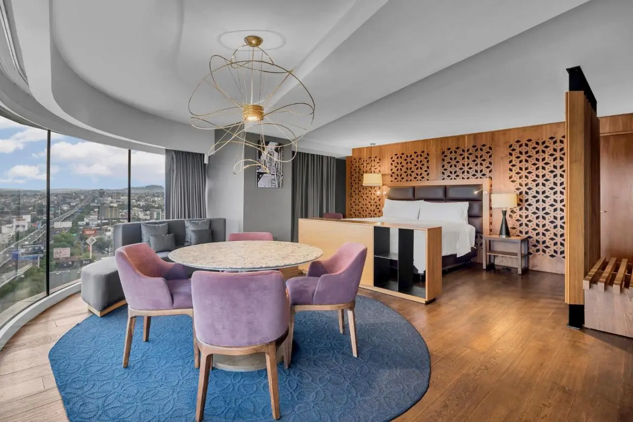 Hotel lounge seating with a rose-coloured chair and a patterned rug