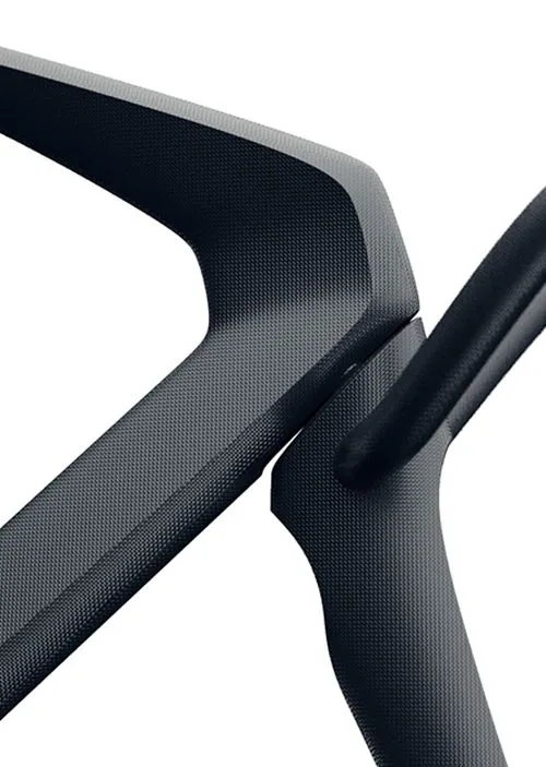Macro of a black moulded frame — a woven-textured arm crossing a rounded strut